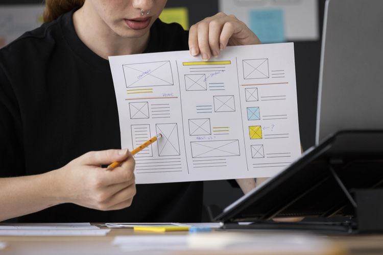 female web designer taking notes in office